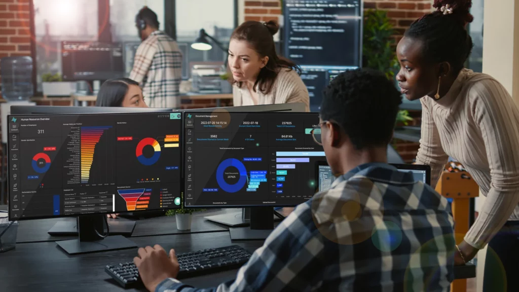 Office colleagues looking at OQLIS dashboards on screens